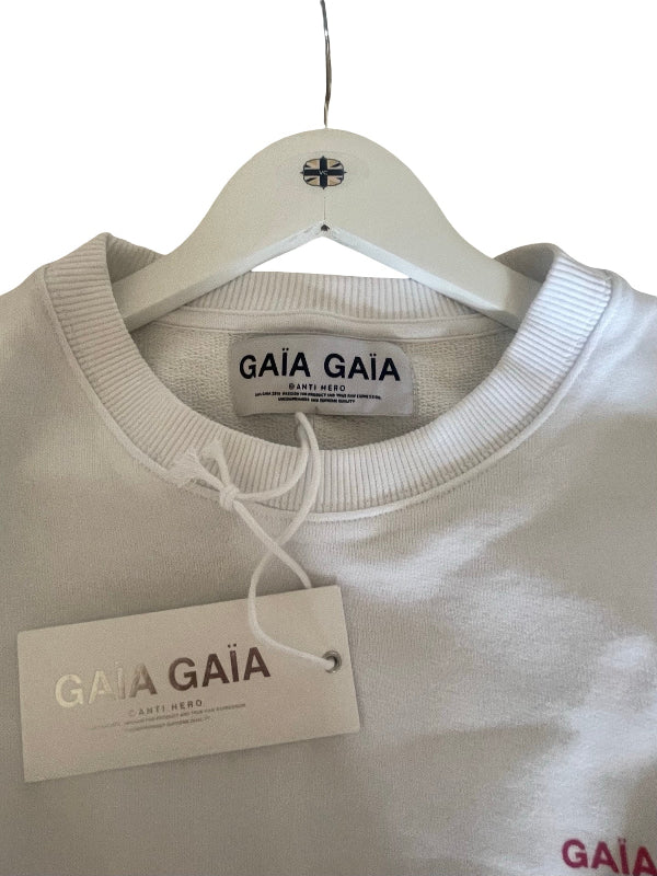 A close-up of a light gray crewneck sweatshirt hanging on a white plastic hanger with a branded GAIA GAIA paper tag attached. The brand name 'GAIA GAIA' is clearly visible on both the neck label and the hangtag.