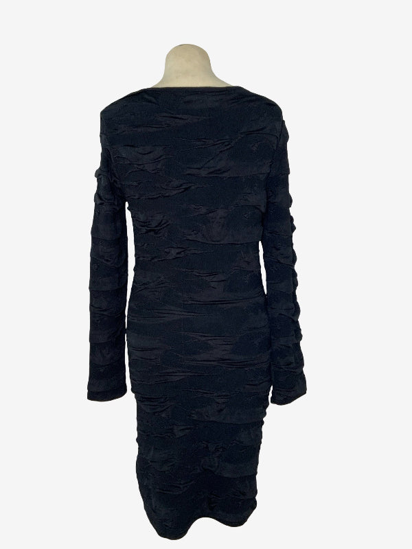 A black long-sleeve ruched body con dress displayed on a mannequin from the back, set against a plain light gray background.