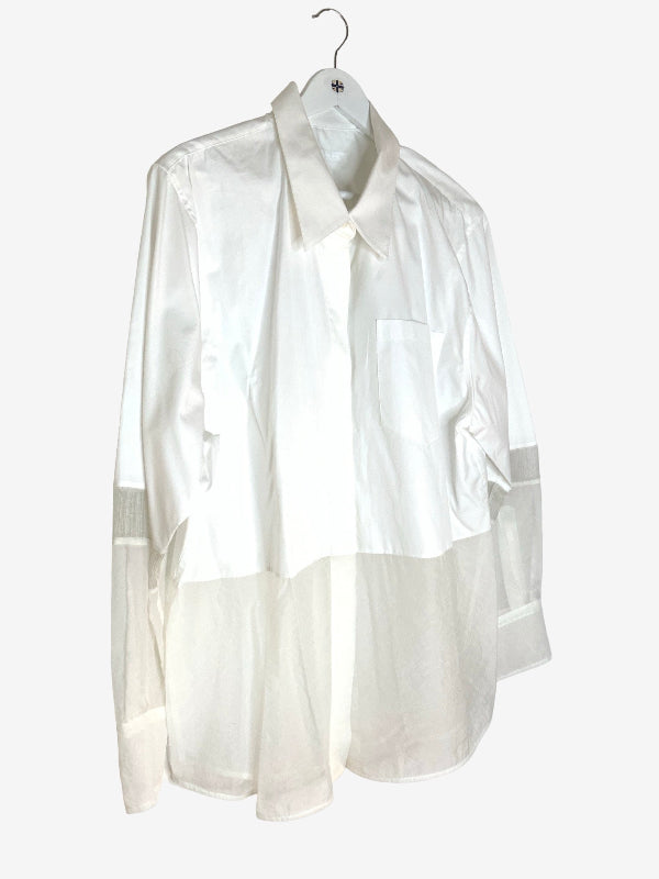 A white long-sleeve shirt with a sheer, semi-transparent lower half and matching sheer cuffs, hanging on a white hanger against a light gray background.