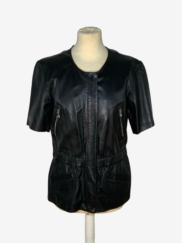 A black lambskin leather short-sleeve jacket with front zipper pockets and a drawstring waist, displayed on a cream mannequin torso against a light gray background.