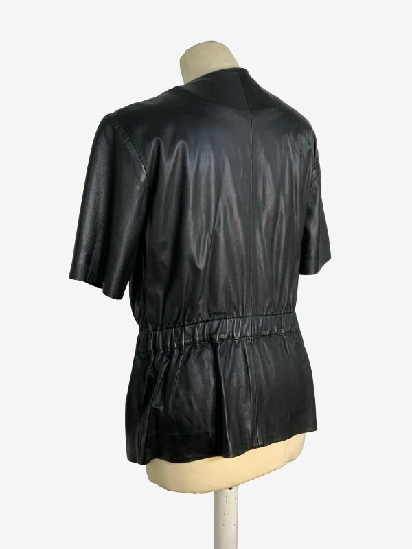 Black lambskin leather short-sleeve top with a gathered peplum waist, shown from the back on a mannequin torso against a white background.