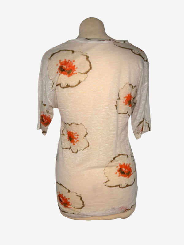 A cream-colored short-sleeve top displayed on a dress form mannequin, featuring a pattern of large white flowers with orange centers and brown outlines.