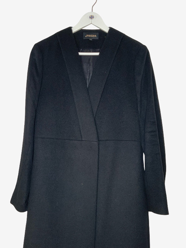 A black long coat with a shawl collar, hanging on a white hanger against a plain white background. The brand label inside the collar reads 'Jaeger'.