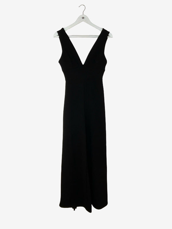 Black jumpsuit on a hanger against a white background