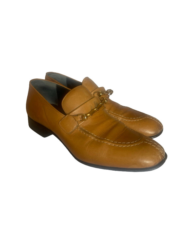 A pair of ladies  tan leather penny loafers with a decorative gold-tone metal tassel detail across the vamp, shown against a plain white background.