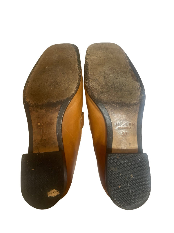 A pair of worn brown leather shoes shown from the sole, displaying the tan insole with the brand name JOSEPH embossed and the black rubber outsole.