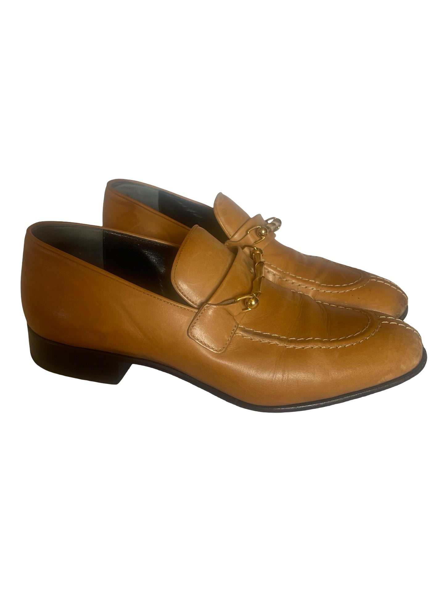 A pair of ladies  tan leather loafers with a decorative tassel detail on the vamp, photographed against a plain white background.