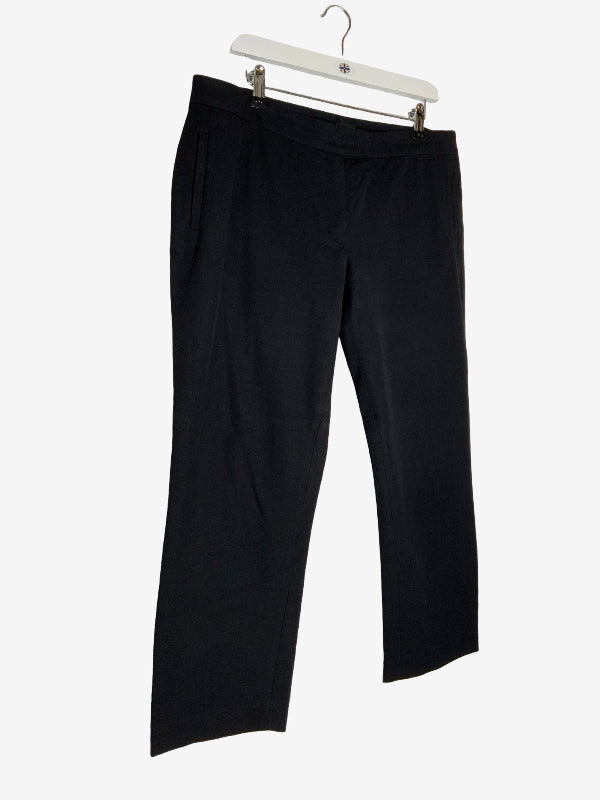 Black wide-leg cropped pants hanging from a white plastic hanger against a light gray background.
