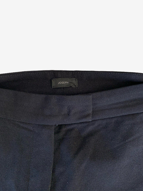 Close-up of the waistband of dark navy trousers, showing a black fabric label with the brand name JOSEPH in white text.