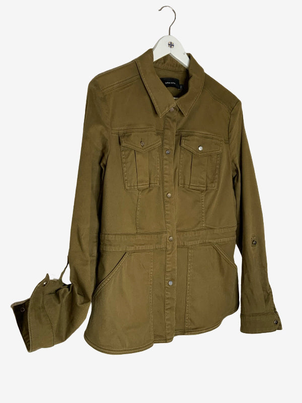 An olive green utility field jacket with four front pockets, hanging on a white hanger against a light gray background. One sleeve attached to show tag and fastener where sleeve can be rolled up and fixed