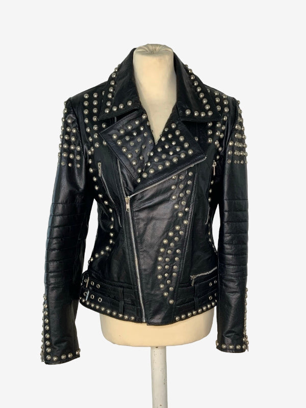 A black leather moto jacket with silver studs, displayed on a beige mannequin torso against a light gray background