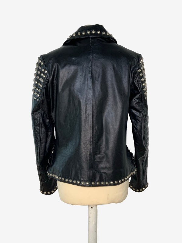 Black leather jacket with silver studs on the shoulders and collar, displayed on a cream dress form against a white background.