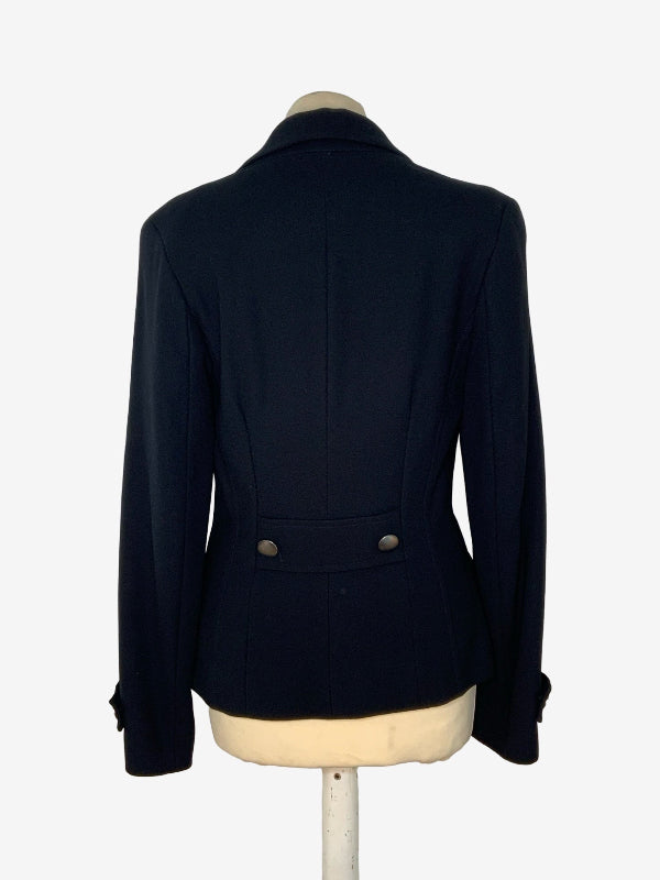 A black tailored blazer shown from the back on a cream-colored dress form mannequin against a plain white background
