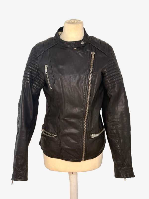 A black leather motorcycle jacket with silver zippers, displayed on a beige mannequin torso against a light gray background.