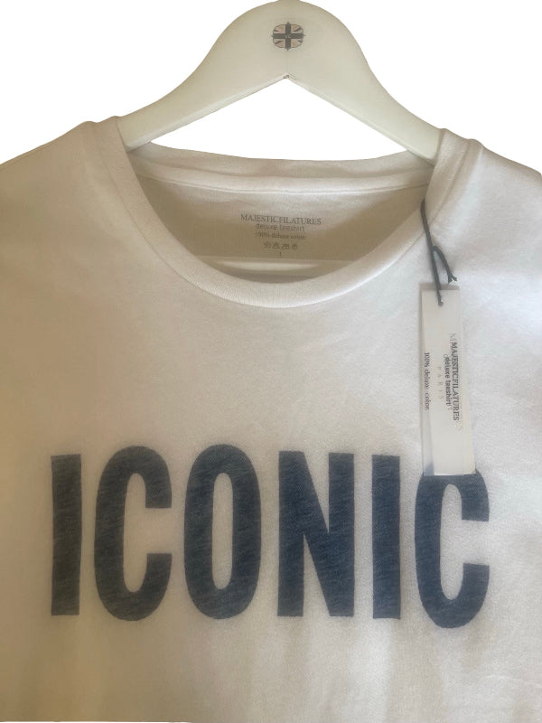 A white crewneck T shirt  by Majestic Filatures  Paris, featuring the word 'ICONIC' printed across the front in a dark gray textured font. The T shirt  is displayed on a white hanger with a brand tag attached.