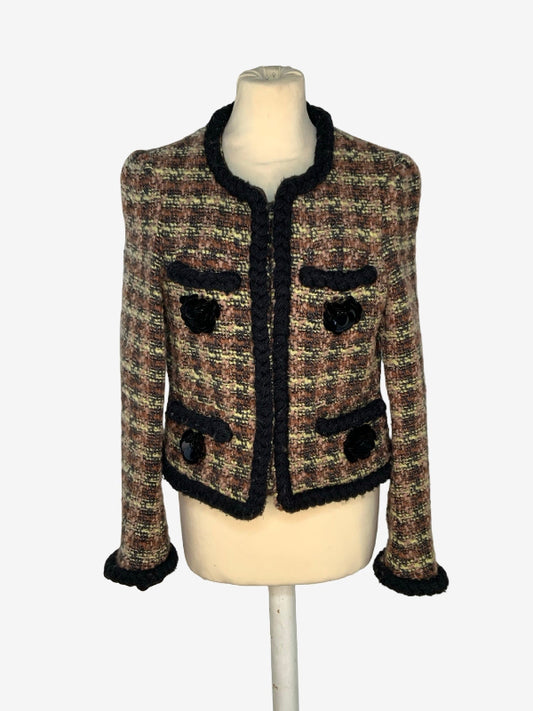 A cropped tweed jacket with black trim, displayed on a cream mannequin torso against a light gray background.