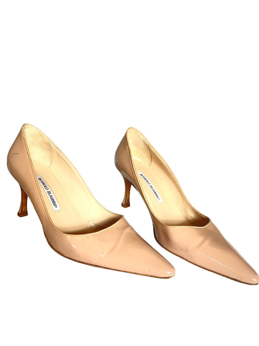 A pair of pointed-toe kitten heel pumps in a glossy nude beige patent leather, shown against a plain white background. The brand name 'MANOLO BLAHNIK” is visible on the insole.