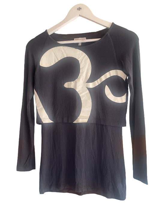 A long-sleeve top on a wooden hanger, featuring a dark blue gray body with a large cream-colored abstract graphic print across the chest and a peplum hem.