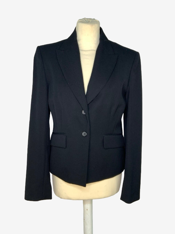 A black tailored blazer jacket displayed on a cream-colored mannequin torso against a light gray background.