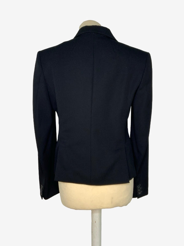 A black tailored blazer shown from the back on a cream-colored mannequin torso, set against a plain white background.