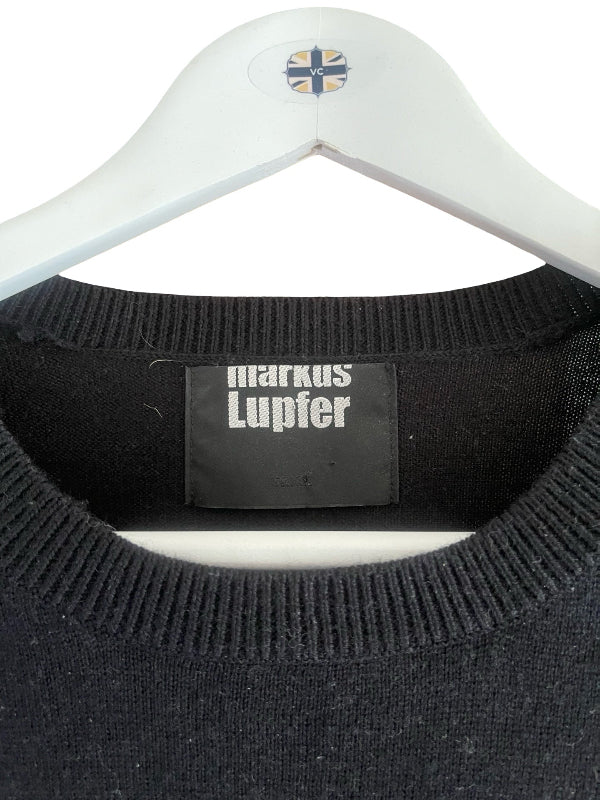 Close-up of a black knit sweater on a white hanger, showing the Markus Lupfer brand label inside the collar.