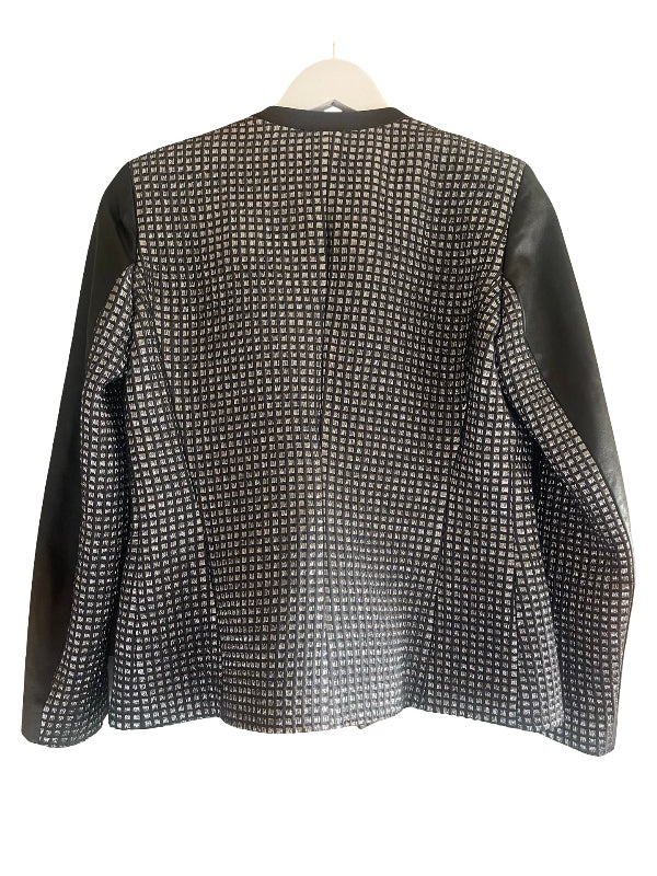 A women's long-sleeve blazer shown from the back, featuring a black and silver  micro-patterned body and solid black leather sleeves, hanging on a white hanger against a white background.