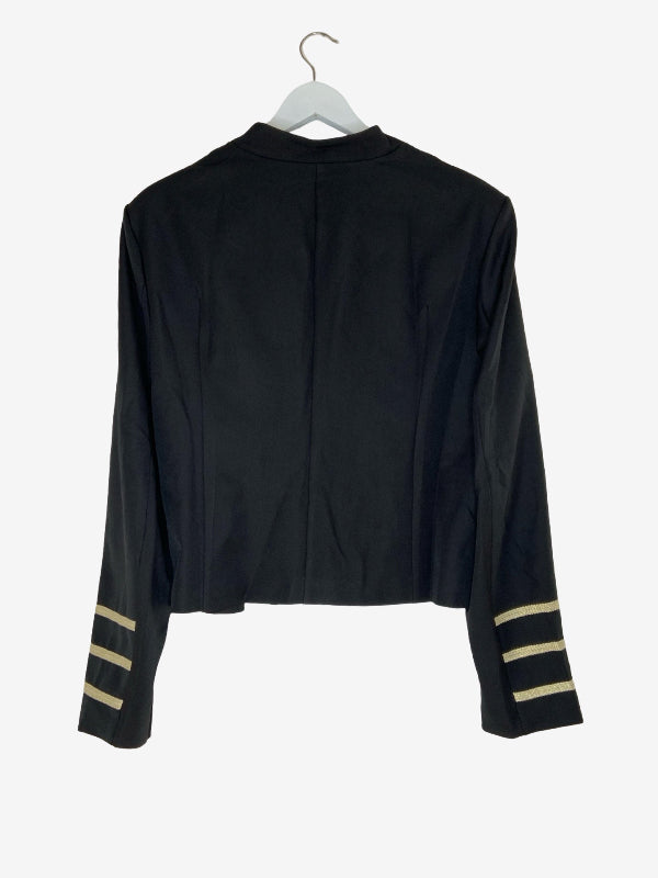A black long-sleeve cropped jacket with gold stripes on the cuffs, shown from the back on a white hanger against a light gray background.