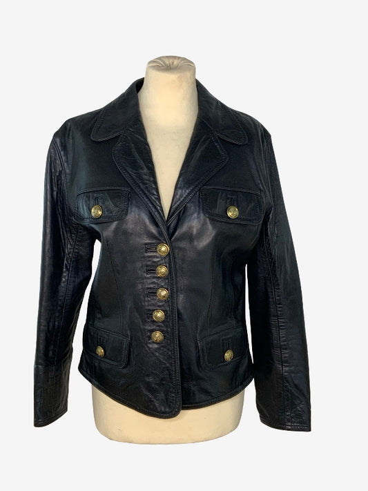 A black leather jacket with gold-tone buttons, displayed on a beige mannequin torso against a light gray background.