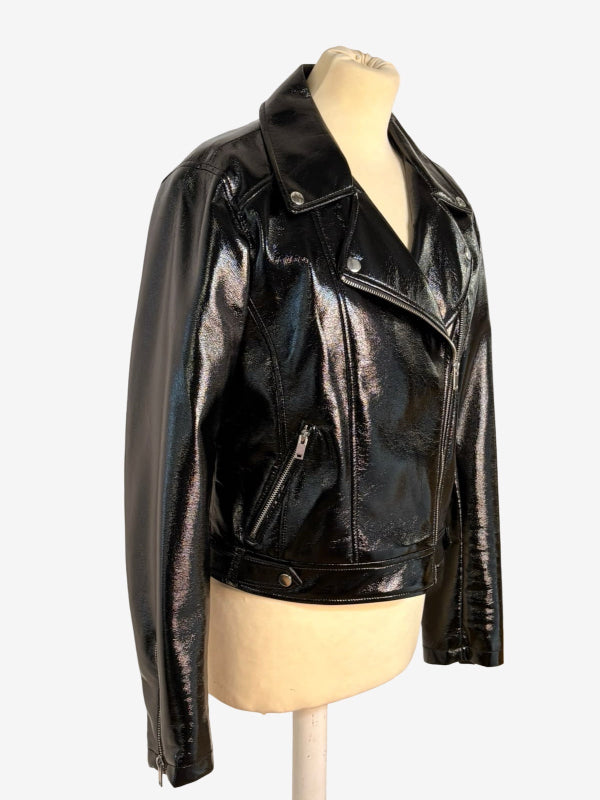 A black glossy faux-leather moto jacket displayed on a beige mannequin torso against a plain white background.