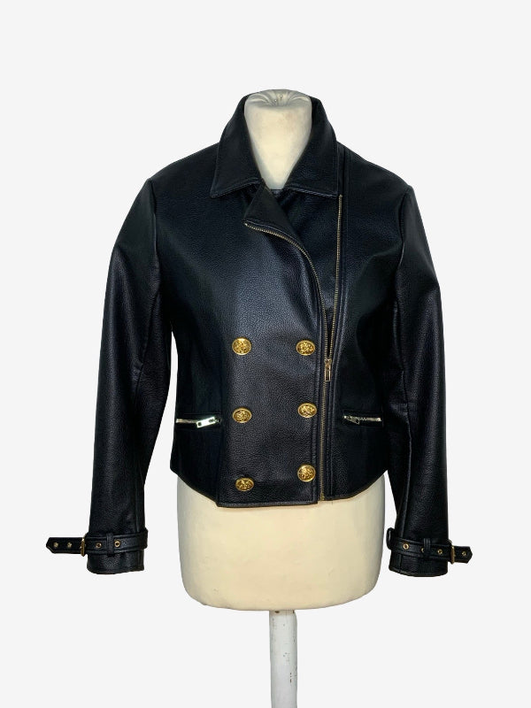 A black leather motorcycle jacket with gold-tone hardware, displayed on a cream-colored mannequin torso against a plain white background.
