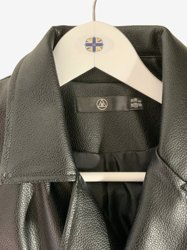 A close-up of a black pebbled faux-leather jacket hanging on a white hanger with a circular logo patch on the collar. The interior neck label shows a circular triangle logo and a size tag.