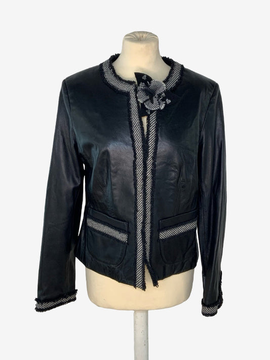 A black leather jacket with gray and white striped trim, displayed on a cream-colored mannequin torso against a light gray background.