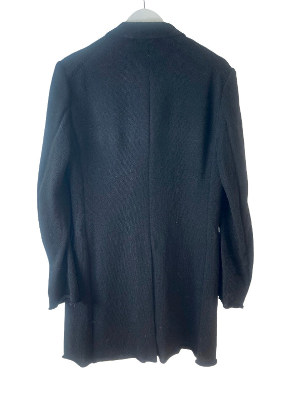A black wool-blend coat hanging on a white hanger against a plain white background, showing the back view.