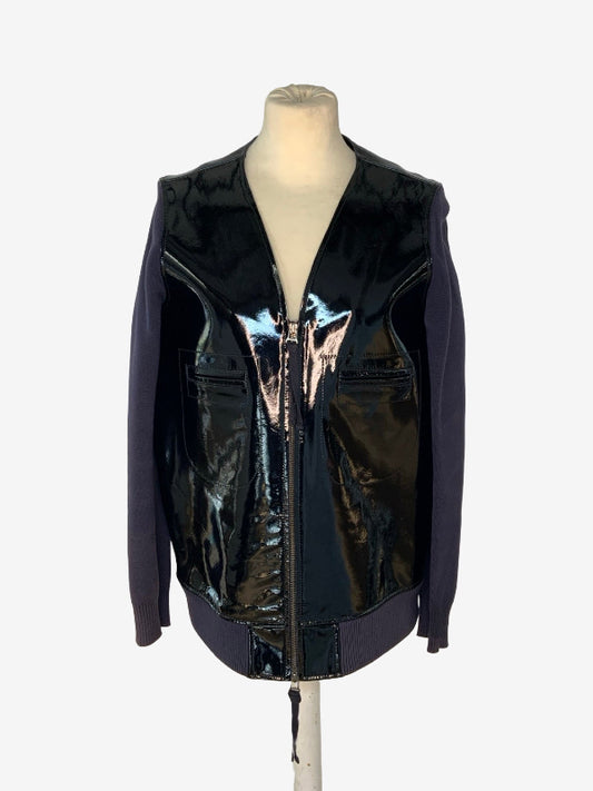 A sleeveless zip-front vest jacket with a glossy black patent leather front and dark purple sleeves, displayed on a mannequin torso against a light gray background.