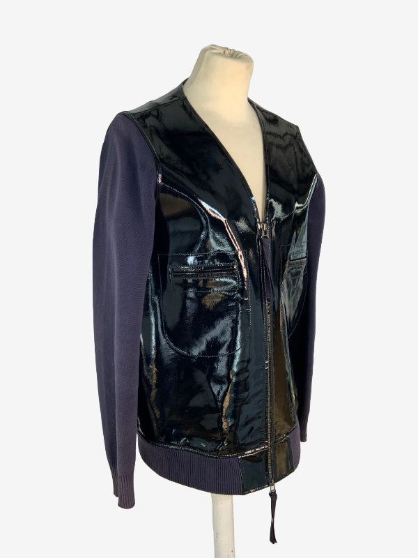 A cotton knitted sleeve zip-front jacket with glossy black patent leather panels and dark purple knit sleeves, displayed on a mannequin torso against a light gray background