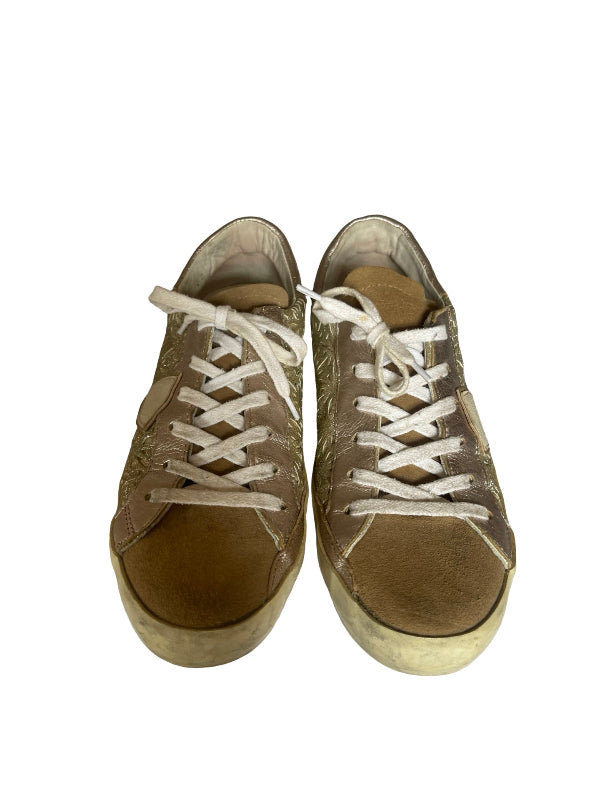 A pair of distressed low-top sneakers in a muted brown and beige colorway with white laces, shown from a top-down view on a white background.