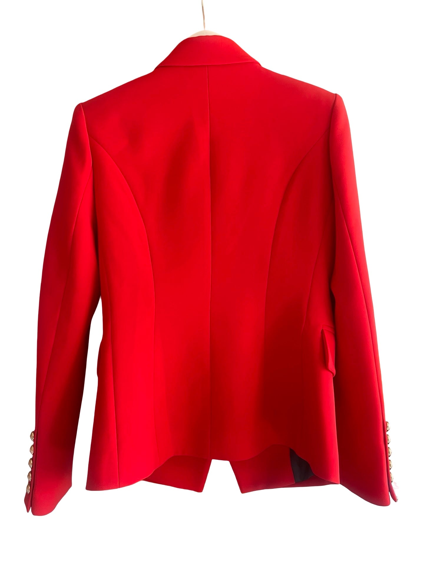 A bright red tailored blazer shown from the back, hanging against a plain white background.