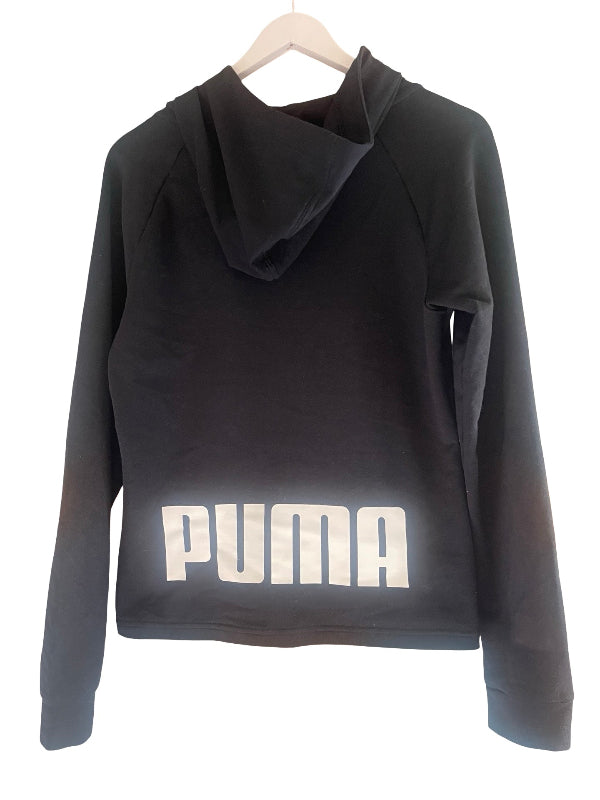 A black Puma cropped hoodie with a large white logo printed across the front, hanging on a wooden hanger against a white background.