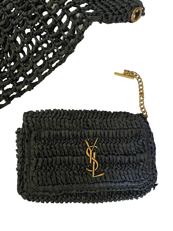 A black woven straw clutch bag with a gold-tone monogram logo and a gold chain link accent, shown on a plain white background.