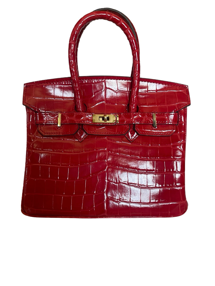 A red crocodile-embossed leather handbag with gold-tone hardware, shown against a plain white background.