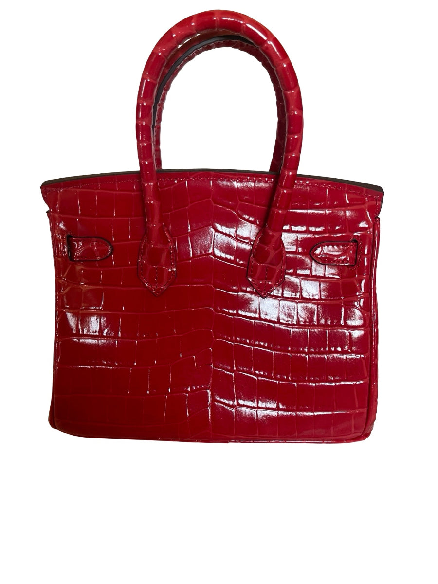 A red crocodile-embossed leather handbag with double top handles and silver-tone hardware, shown against a plain white background.