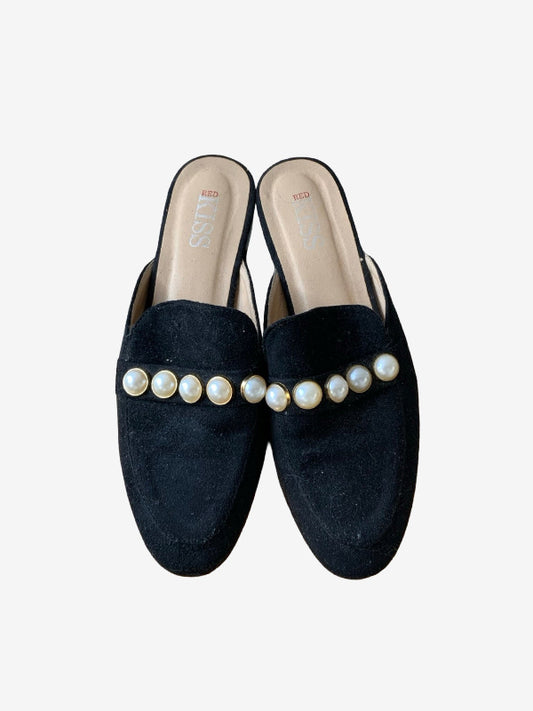 A pair of black faux suede mule loafers with a row of faux-pearl embellishments across the vamp, shown from a top-down view on a light gray background.