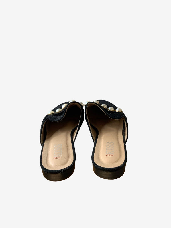 A pair of black faux suede mule sandals with pearl embellishments across the strap, shown from a top-down view on a light gray background.