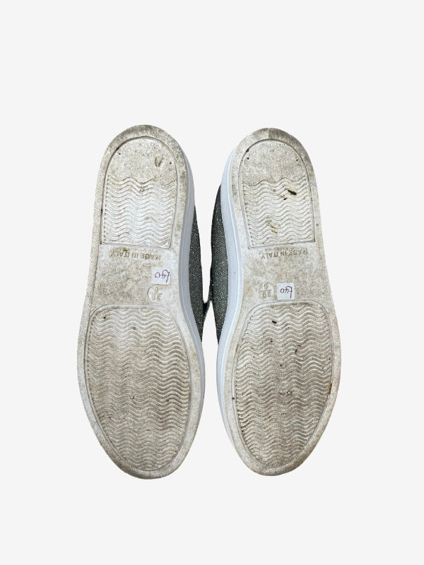 A pair of worn, dirty low-top sneakers shown from the sole view against a plain white background.