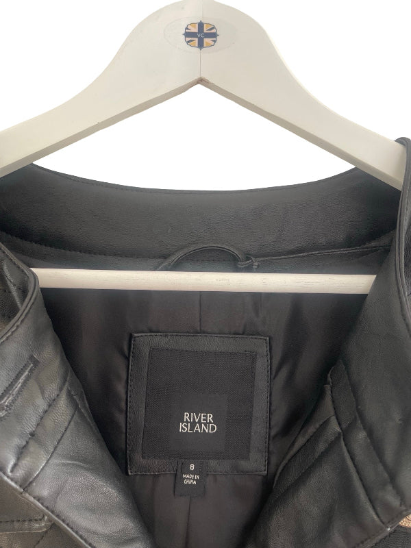 A close-up of a black quilted jacket hanging on a white hanger with a River Island label visible inside the collar.