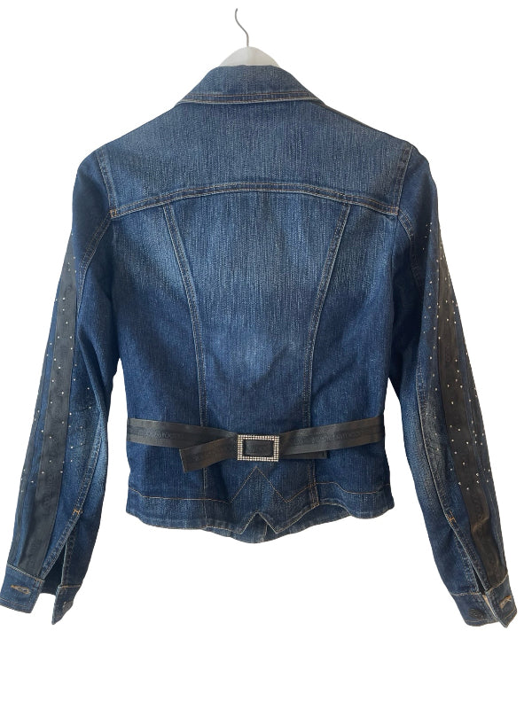 A blue denim jacket with a dark gray belt at the waist and silver rhinestone embellishments on the sleeves, shown from the back on a hanger against a white background.