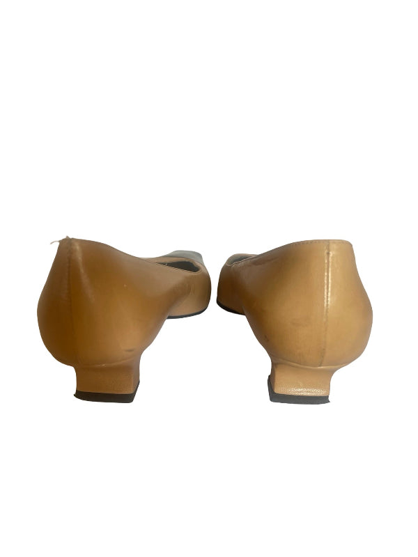 A pair of tan leather low-heel pumps shown from the back, positioned side-by-side against a plain white background.