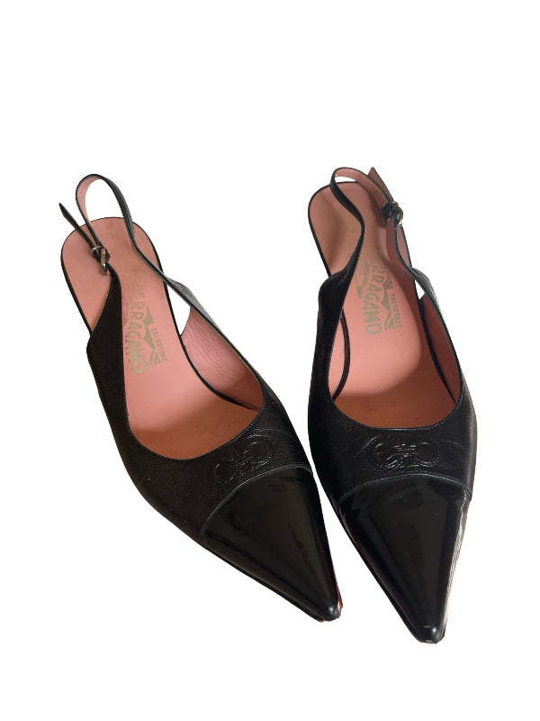 A pair of black pointed-toe slingback pumps with glossy patent leather toe cap uppers and textured logo embossed on the toe, shown on a white background