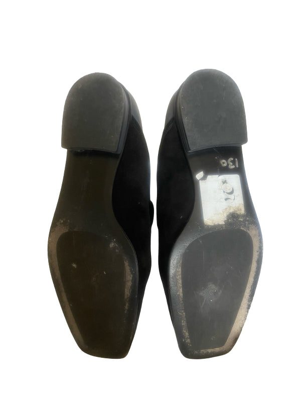 A pair of black pointed-toe flats shown from the bottom, displaying the soles and a small white size sticker on the right shoe, set against a plain white background.