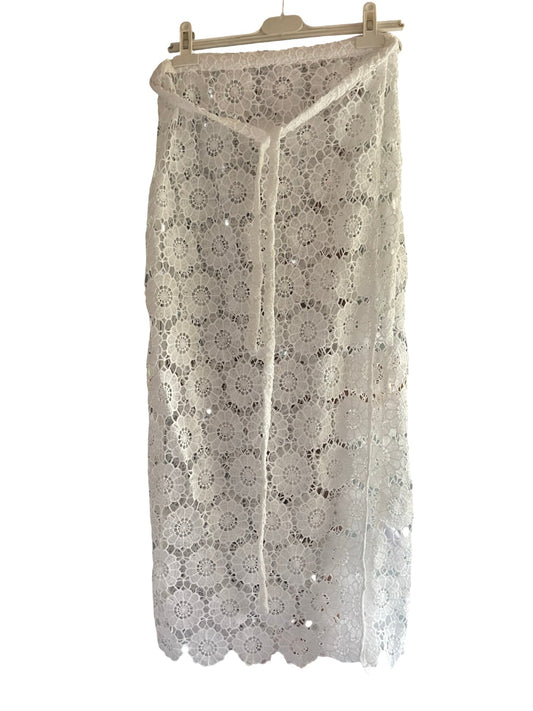 A white crochet lace midi skirt with a V-neckline and tie-front detail, hanging on a wooden hanger against a white background.